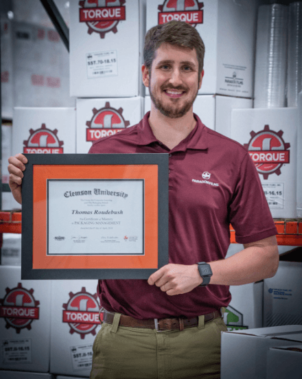 Certificate of Mastery graduate holding their framed Clemson certificate