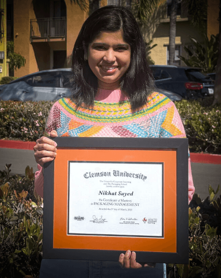 Certificate of Mastery graduate holding their framed Clemson certificate