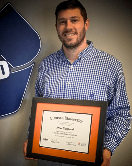 Certificate of Mastery graduate holding their framed Clemson certificate